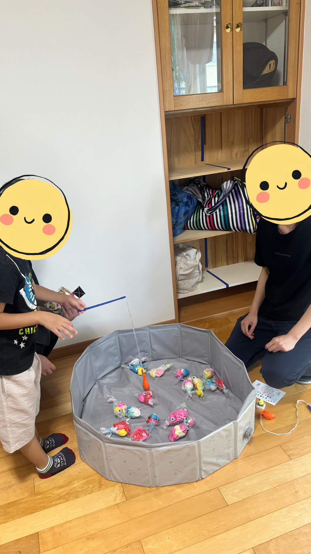 室内で金魚すくいをして遊ぶお子さま